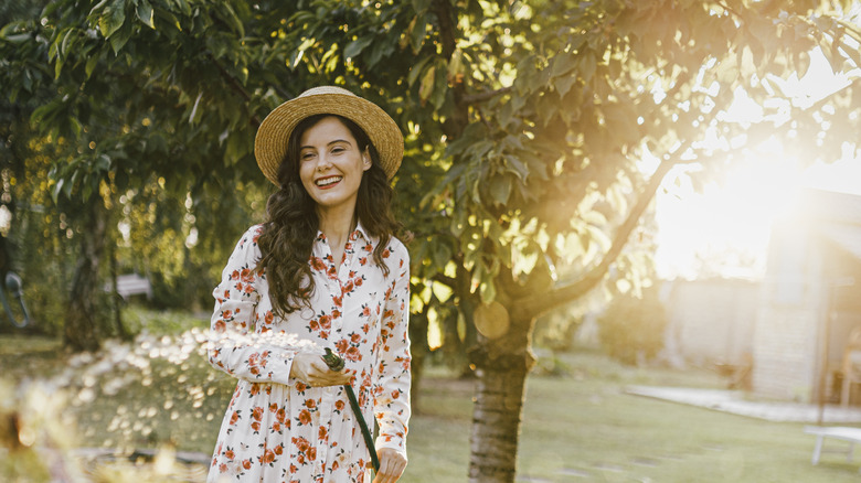 A woman smiles while gardening