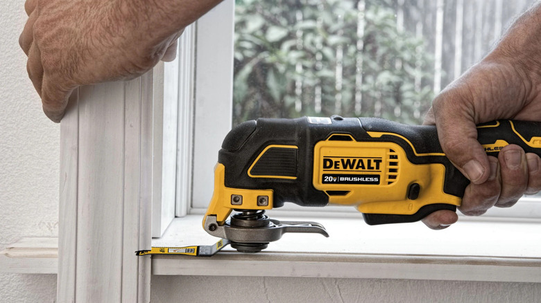 A man using a Dewalt XR 20-volt Max brushless oscillating multi-tool kit.