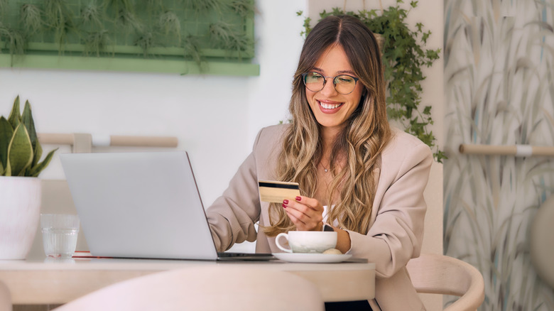 Woman online shopping at a cafe table