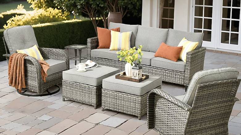 An outdoor patio set in grey with yellow and orange decor accents