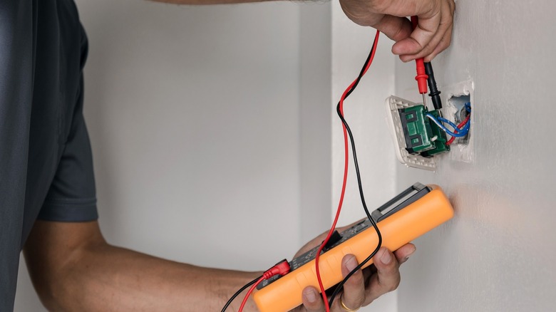 Person testing voltage with a multimeter