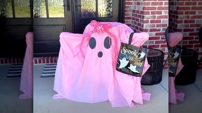 A cute DIY pink ghost candy holder on a front porch