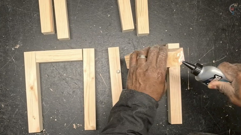 Hands gluing wood dowels