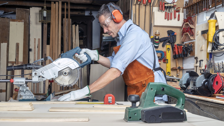 Man cutting wood boards for a DIY in a garage workshop