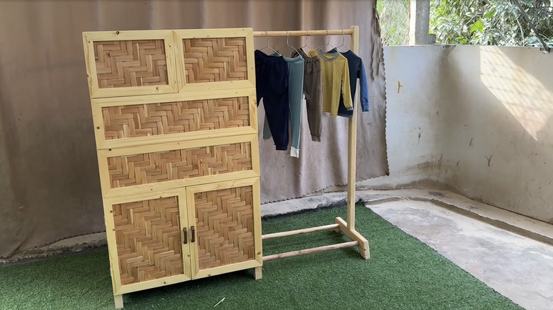 Wooden cabinet made from pallets with an extendable clothing rack