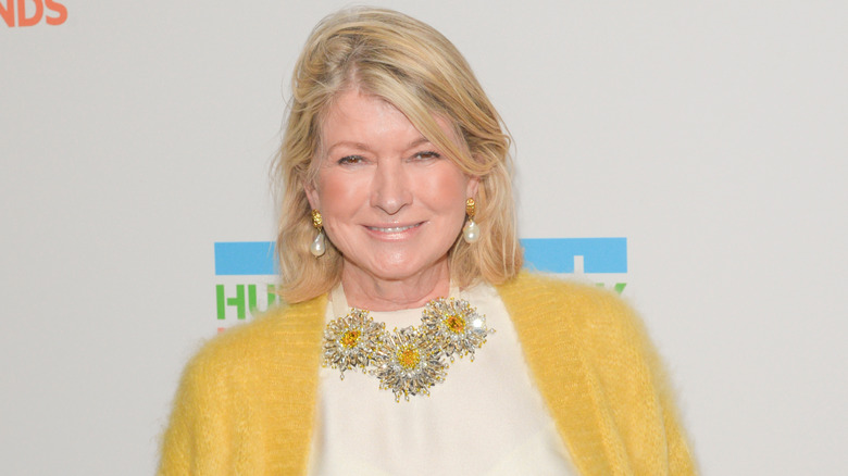 Martha Stewart smiles while wearing a bright yellow sweater and matching statement necklace