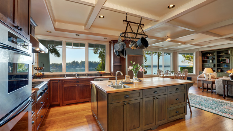 large kitchen island with pots and pans hanging above it