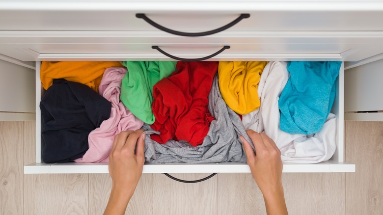 a messy drawer filled with shirts