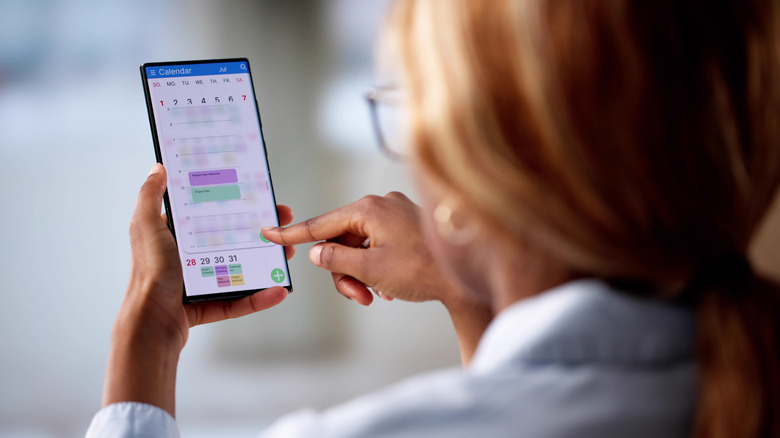 woman scheduling a new event on her phone calendar
