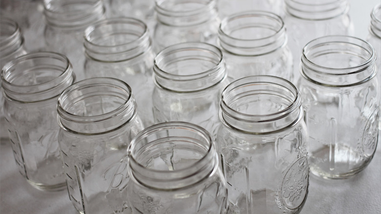 assortment of glass jars storing food and spices on kitchen or pantry shelf