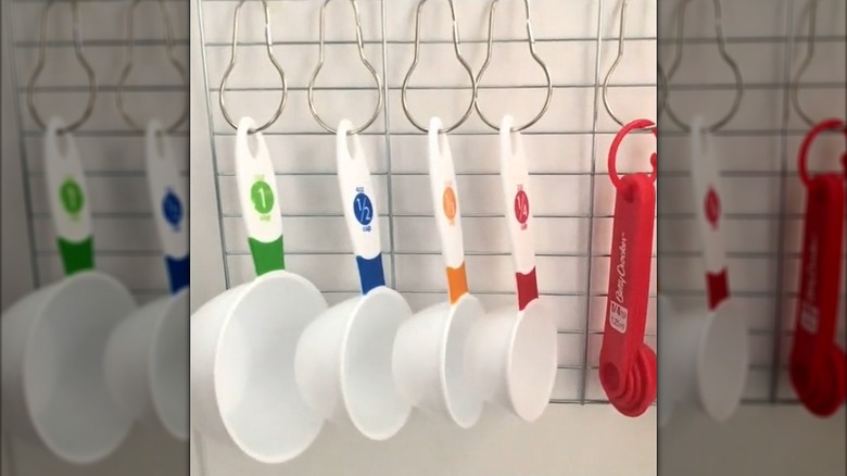 Plastic measuring tools hanging on DIY Dollar Tree rack attached to wall