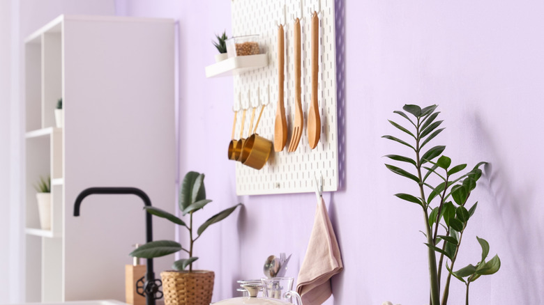 Measuring cups and utensils on pegboard in kitchen