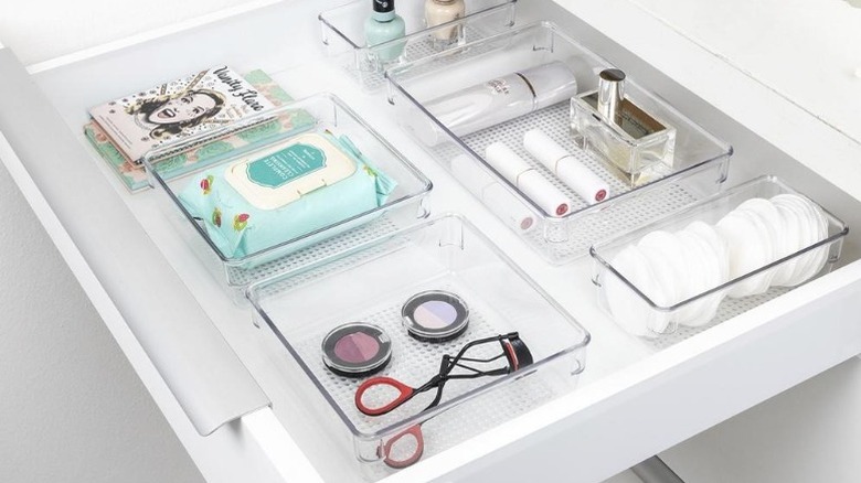 Clear organizers holding personal care items in a vanity drawer