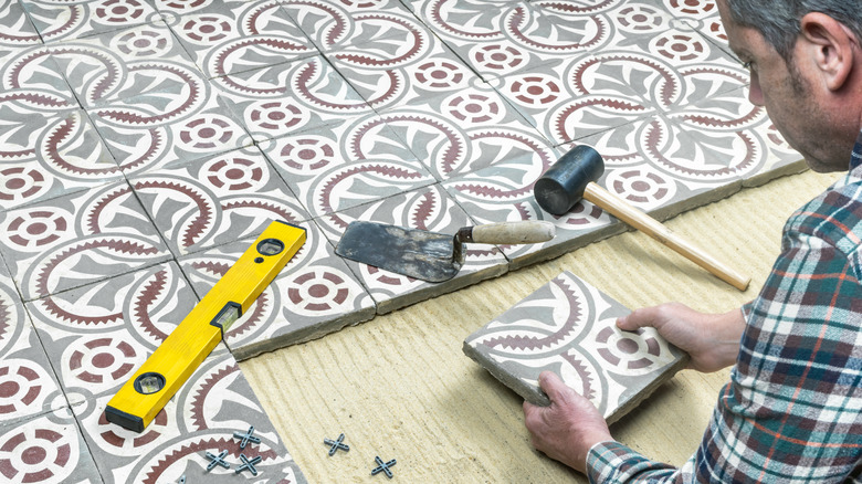 Man laying decorative floor tile