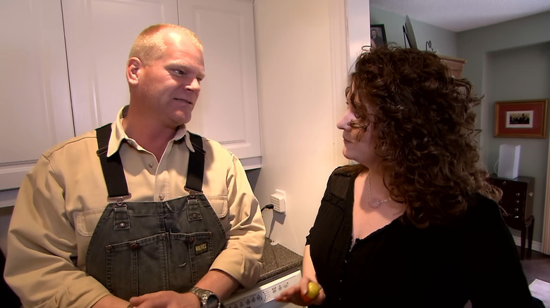 HGTV's Mike Holmes talking to a woman in a kitchen