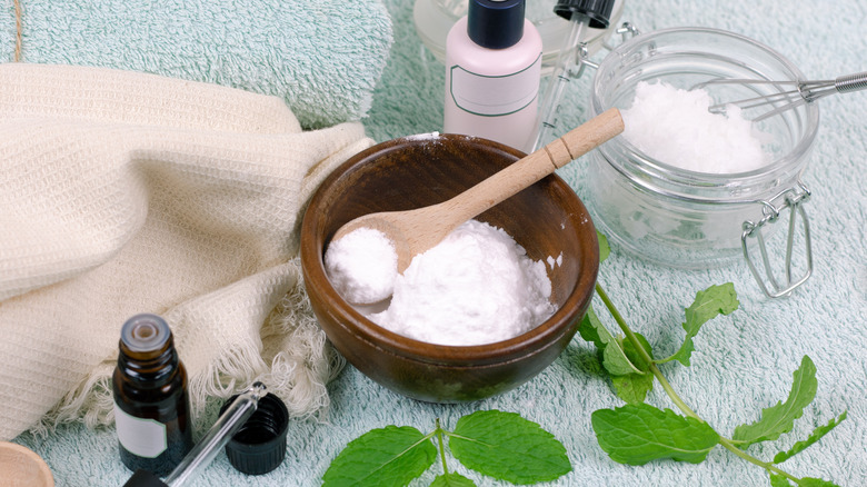 Baking soda in a bowl next to fresh herbs