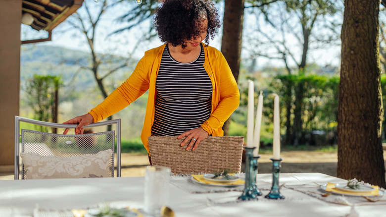 A woman prepares an outdoor table for entertaining