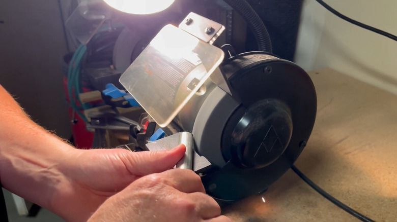 Deburring steel conduit with a bench grinder
