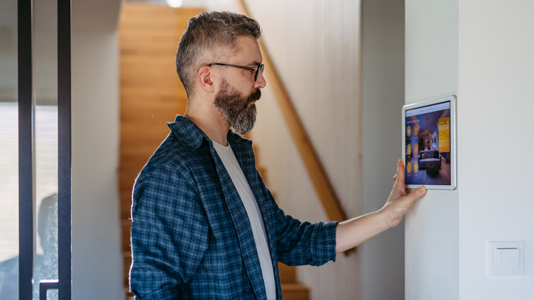 person looking at smart thermostat