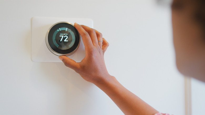 hand setting thermostat at 72 cooling