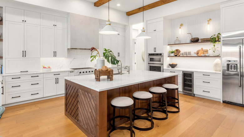 Transitional kitchen with white cabinets and a wood island
