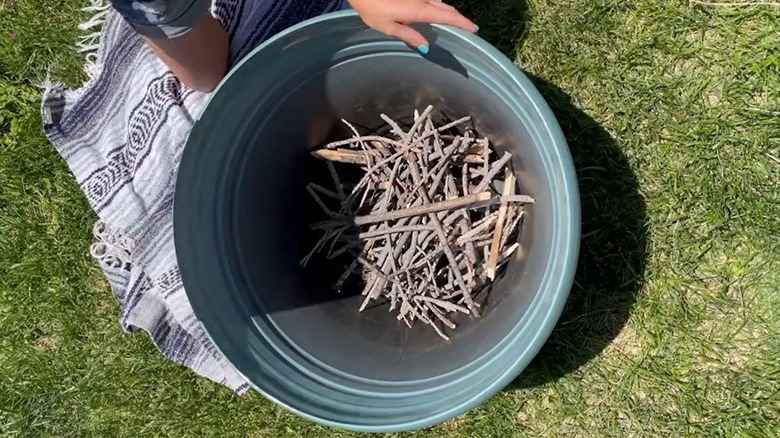 Sticks arranged at the bottom of a large planter