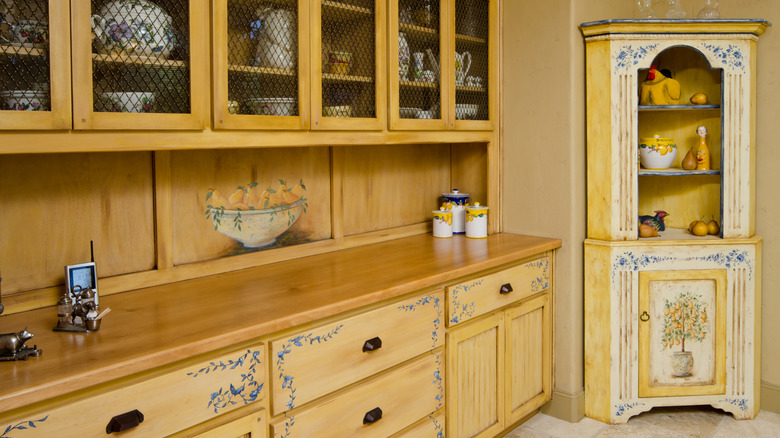 A freestanding corner cabinet integrated with built-in cabinets with design elements