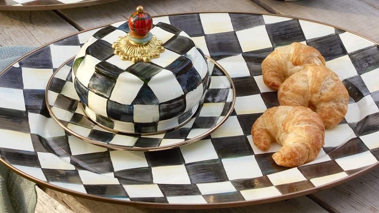 A black and white checkered Mackenzie-Childs serving tray and butter dish