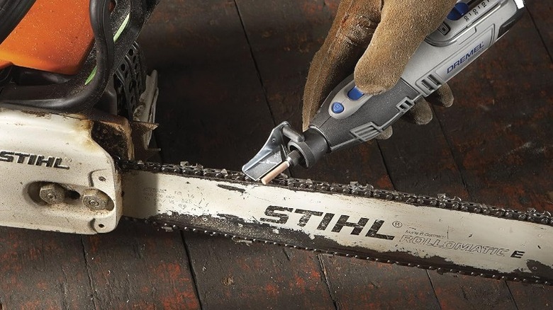 Person using a Dremel rotary tool and attachment kit for sharpening chainsaws