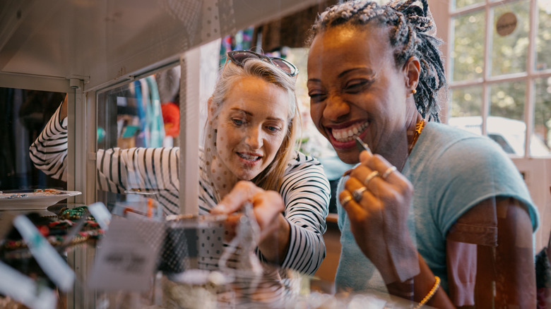 Two women looking in a glass case at a thrift store