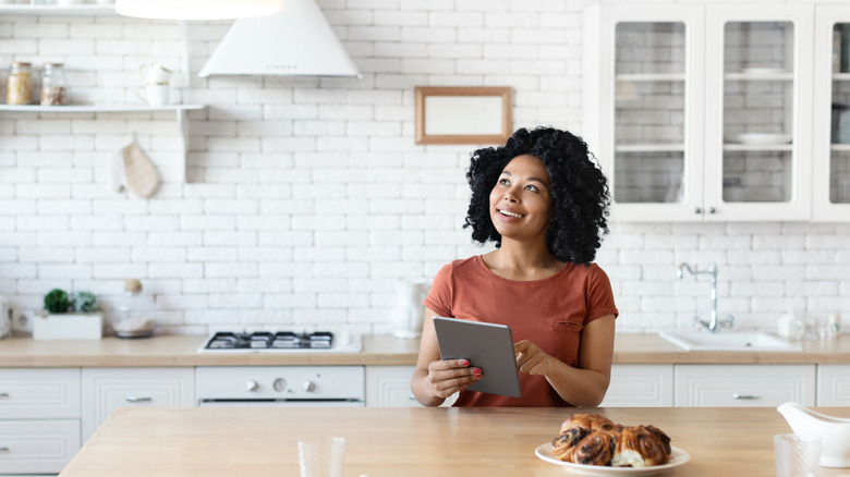 Woman controlling lighting with a tablet