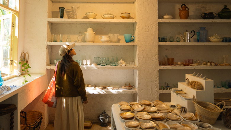 Woman looking at items on shelves of thrift store