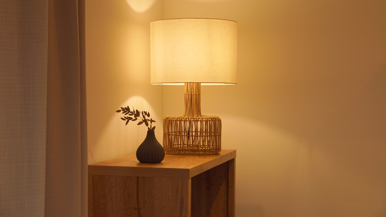 A lamp and vase on a table