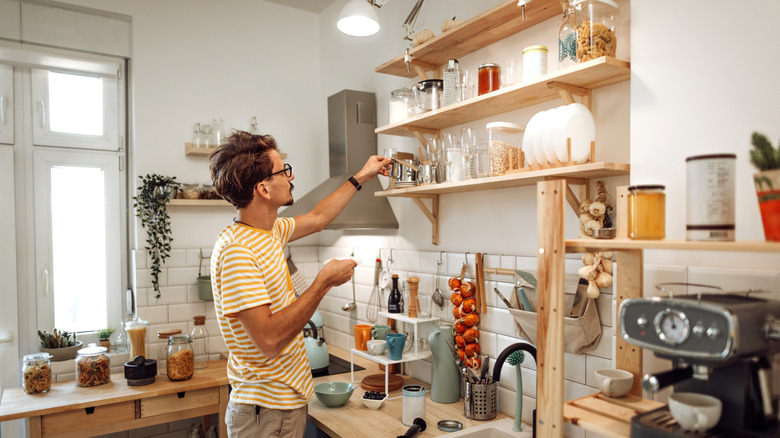 person in small crowded kitchen