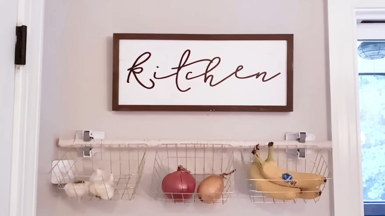 DIY hanging basket kitchen storage under decorative sign on wall
