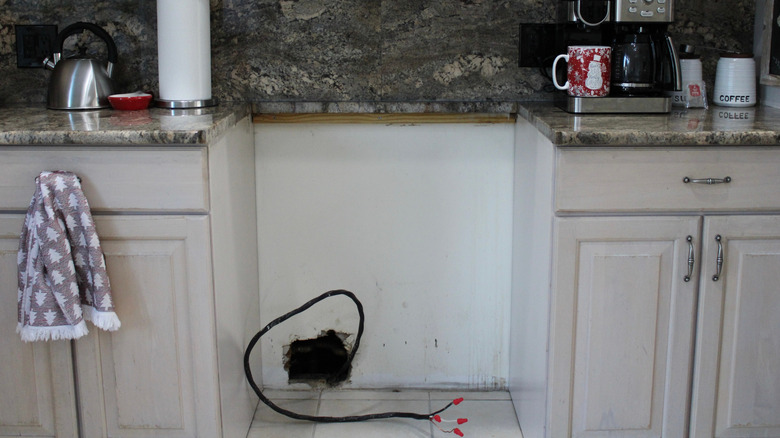 An empty space intended for a stove sits below a kitchen countertop.