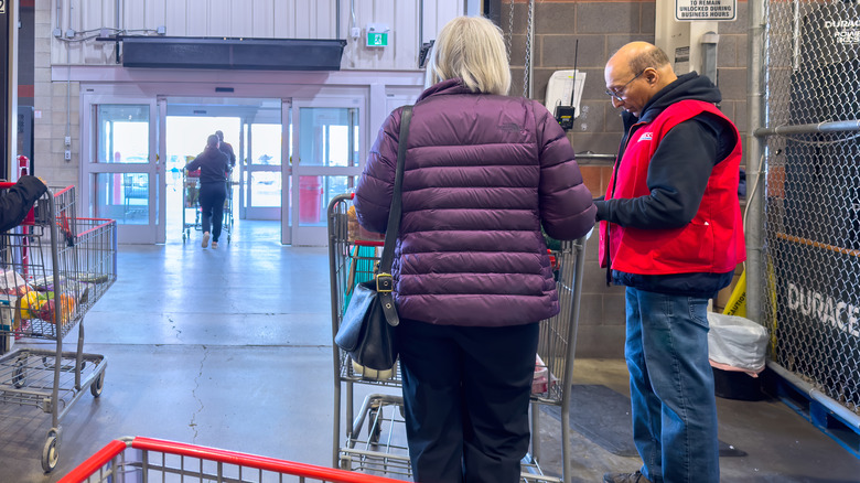 A woman asks a Costco store employee for help