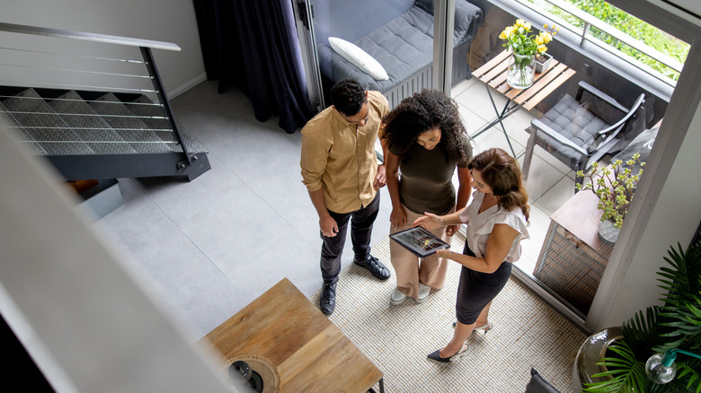A real estate agent talking to a couple in a home