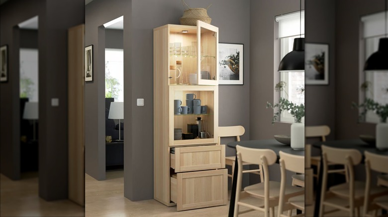 A BESTÅ Storage Combination with glass doors from IKEA is filled with dishes