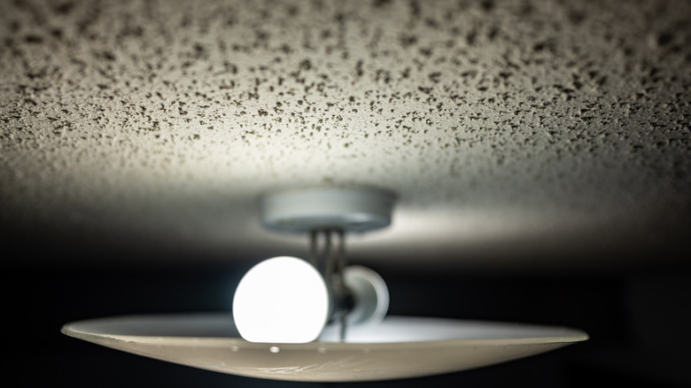 Light fixture illuminating popcorn ceiling.
