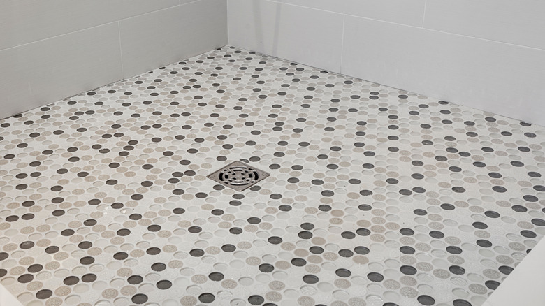 a shower floor with small round tiles