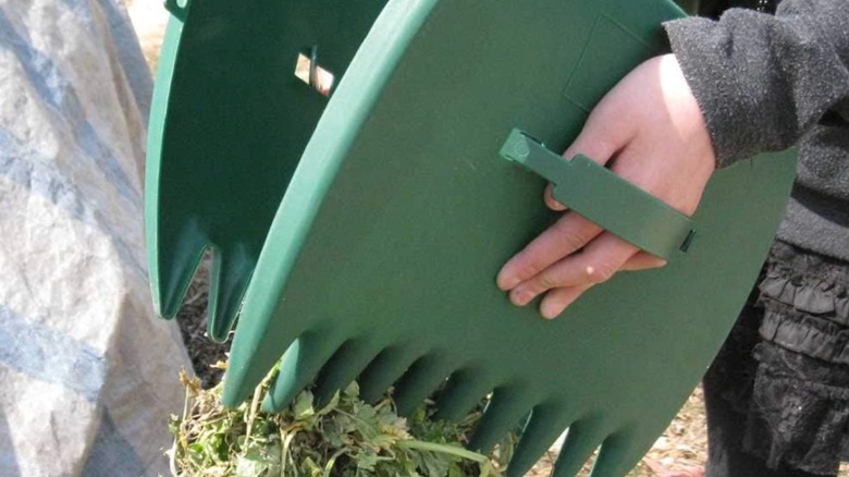 A closeup of the Tookie garden leaf grabbers picking up a pile of debris