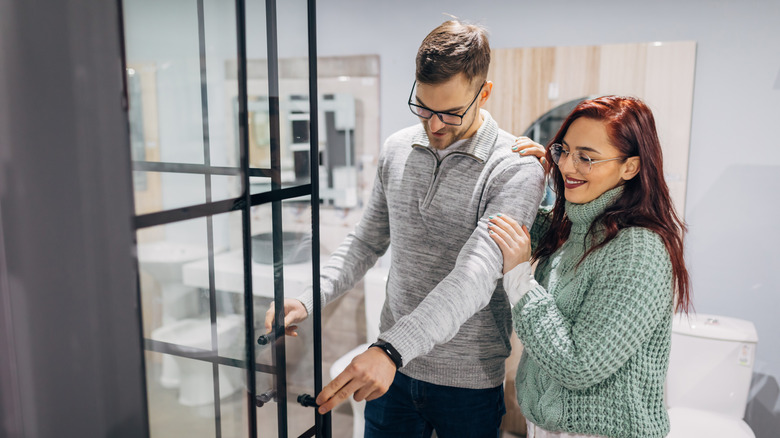 Young couple in a furniture store choosing a shower