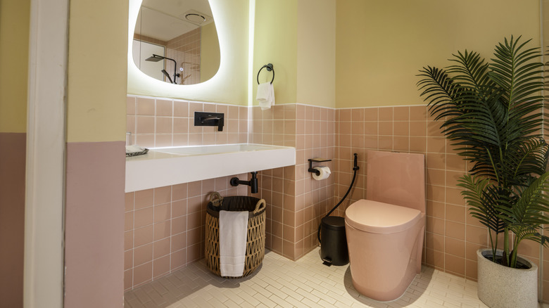 Pastel yellow and pink bathroom with a pink toilet