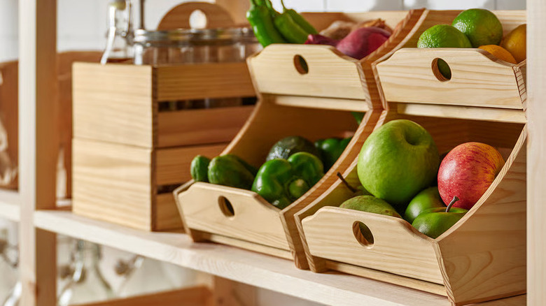 Fresh vegetables are stored in two wooden CHOKLADHAJ Food Storage Boxes from IKEA