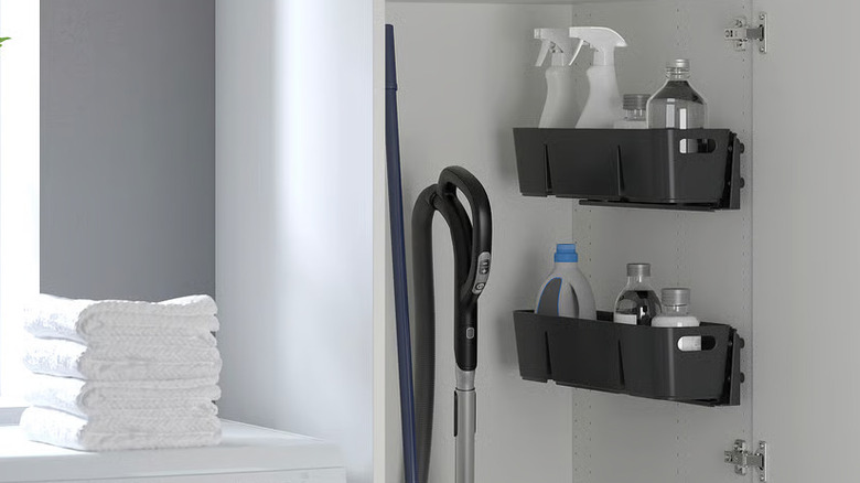 Cleaning supplies sit in two black UPPDATERA Boxes in a tall pantry