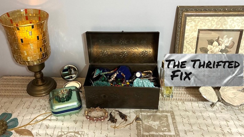 Cluttered jewelry box surrounded by decor
