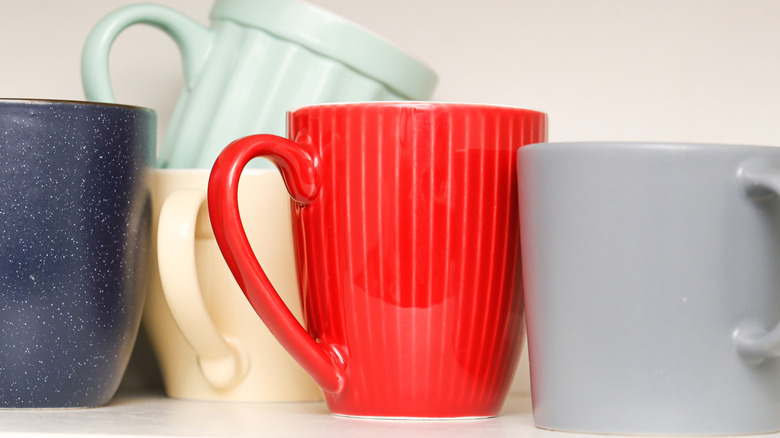 colorful coffee mugs on kitchen shelf