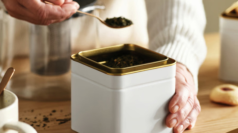 White and gold tin with tea in it on a countertop