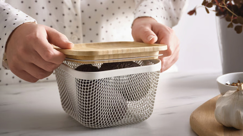 Person putting the lid on a mesh food container
